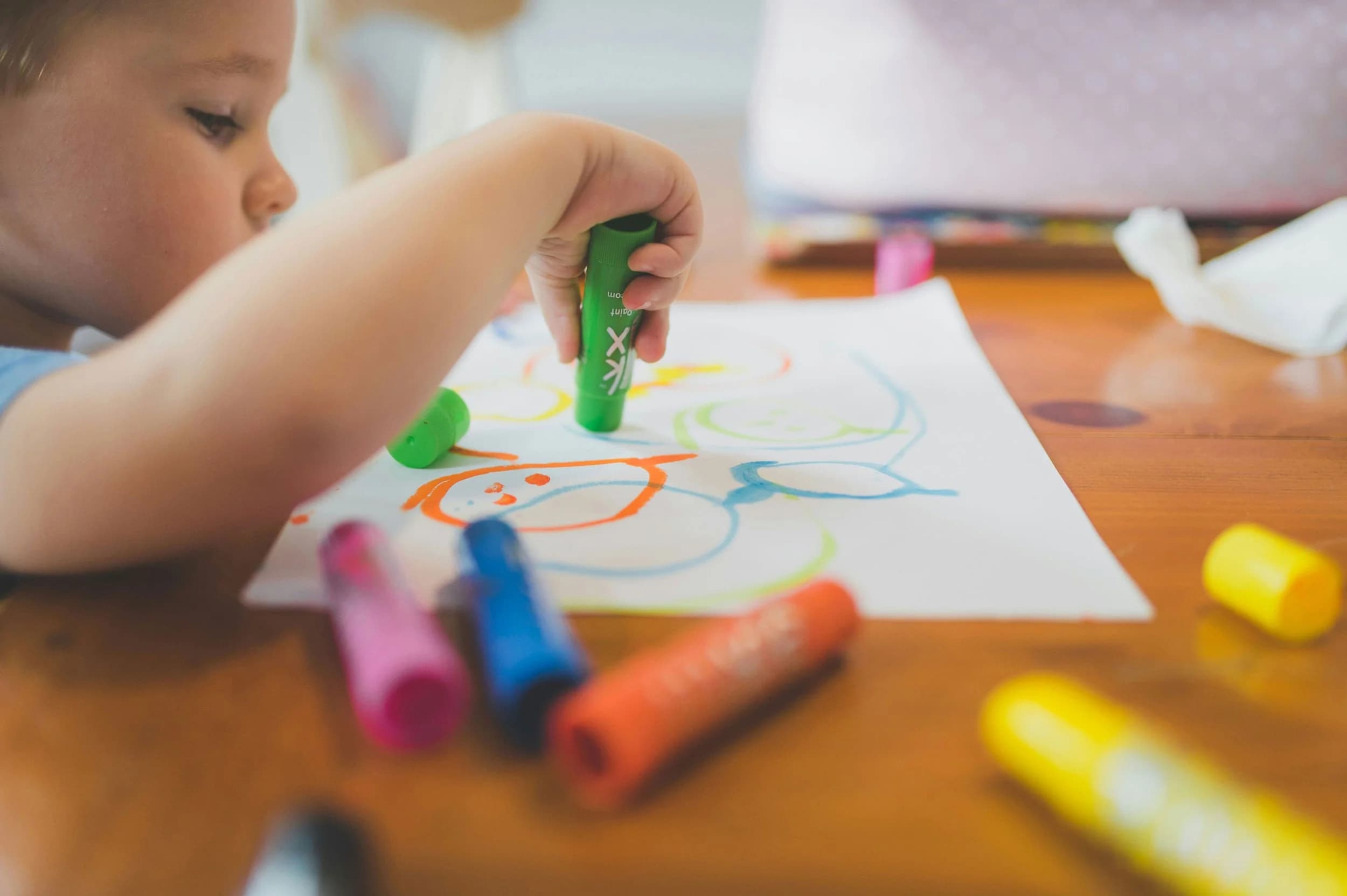 Child drawing with coloured markers